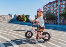 Dziecko uczące się jazdy na rowerku biegowym dopasowanym do wzrostu i długości nóg
