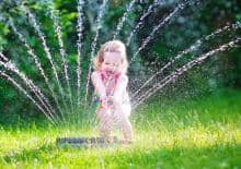dziewczynka-ze-zraszaczem-w-ogrodzie
