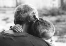 Rodzic spokojnie rozmawiający z dzieckiem i utrzymujący z nim bliski kontakt wzrokowy