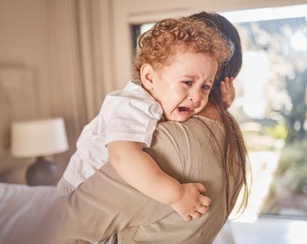 małe dziecko płaczące w ramionach rodzica